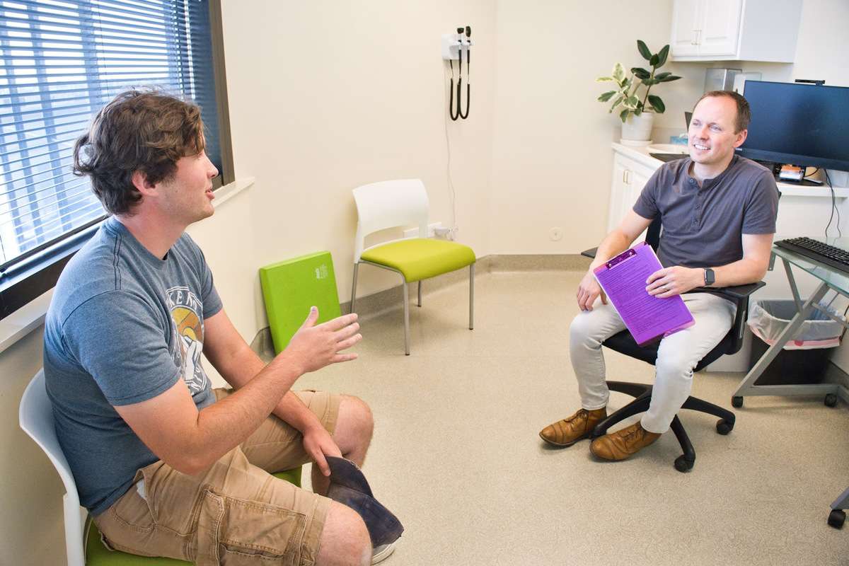 A patient asking a doctor questions at Neural Effects. 