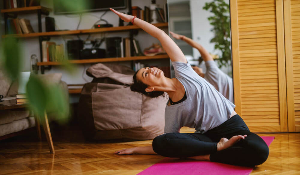 A woman is doing yoga in her living room.