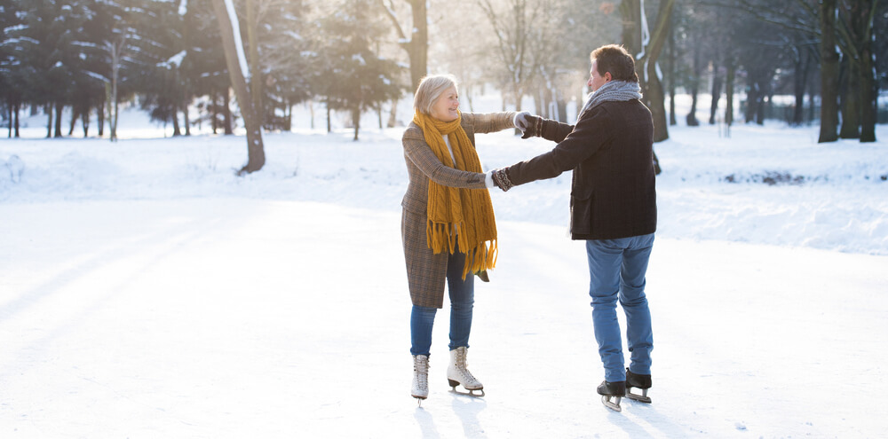 Senior couple ice skating outside