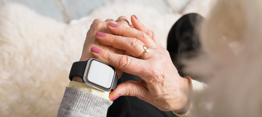 A senior woman looks at her Apple watch