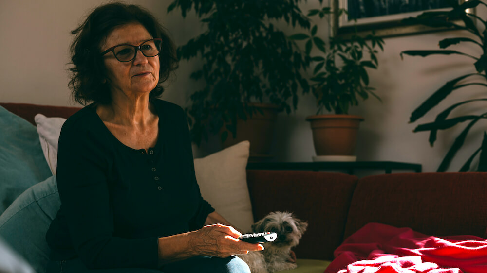 An woman is watching TV.