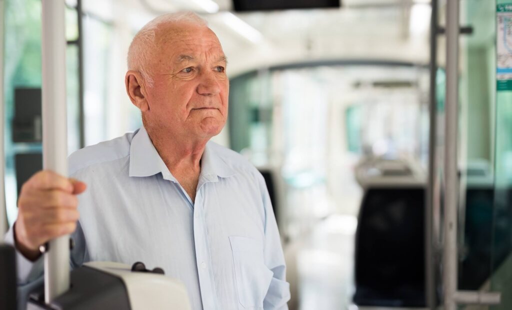 Older gentleman standing on a tram