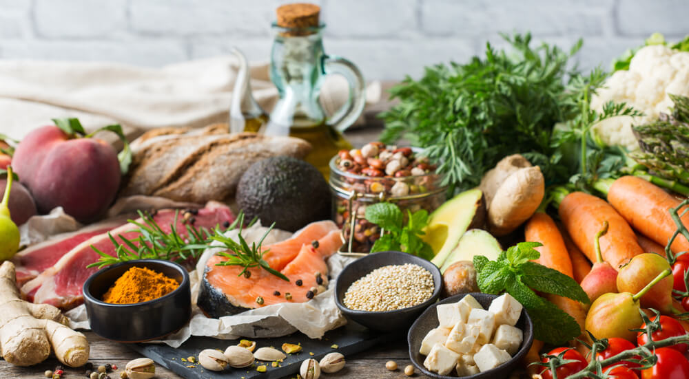 A table filled with healthy food (fruits, vegetables, meat, salmon, cheese)