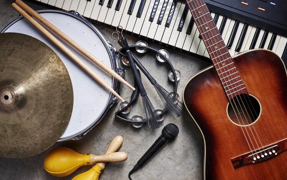 An array of musical instruments including a guitar, keyboard, drum, microphone, and tambourine