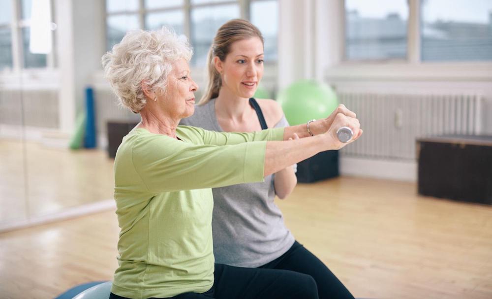 Physical therapist and senior patient exercising